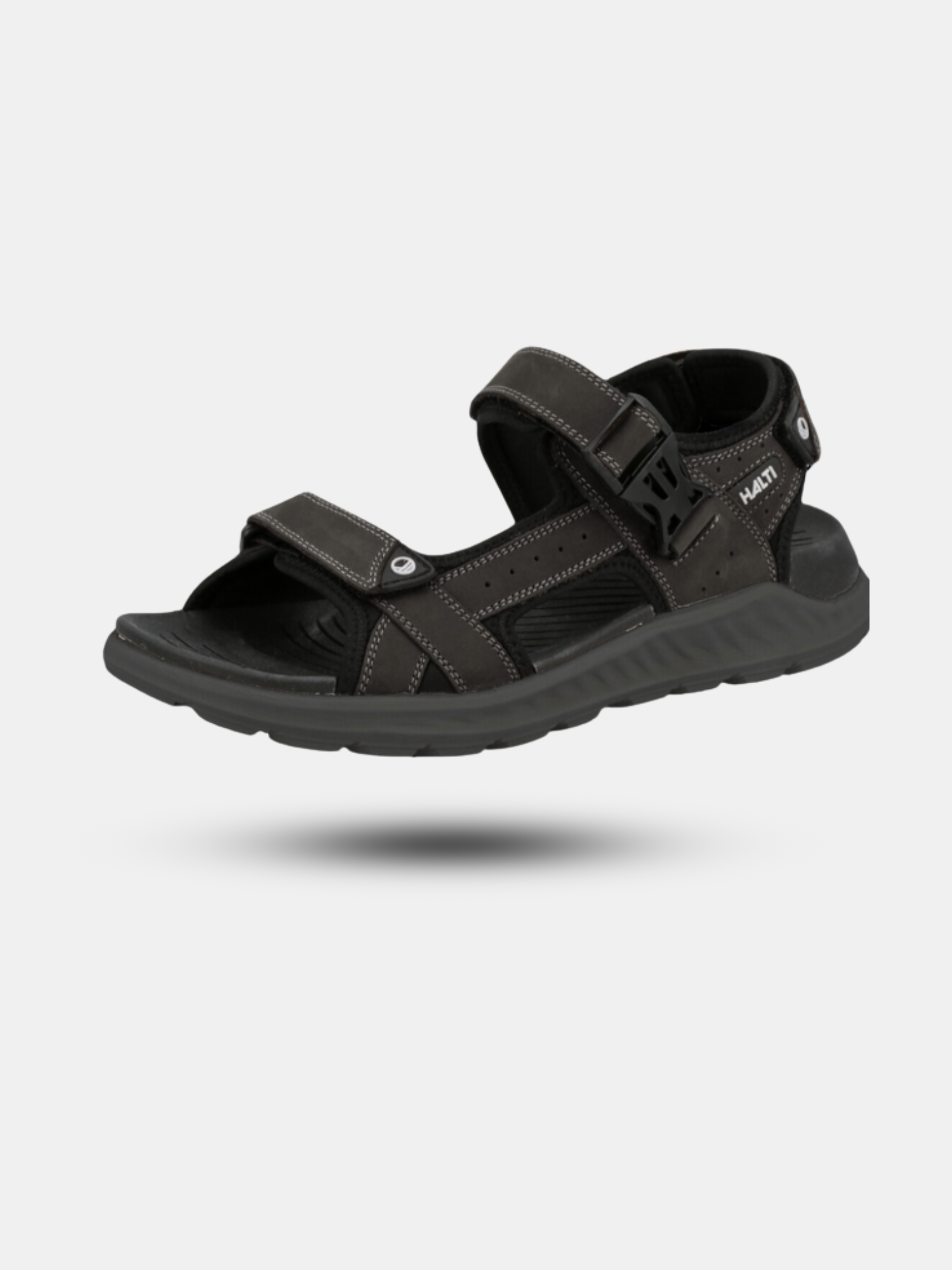 Die Halti Sora Sandale ist eine schwarze Outdoor-Sandale mit verstellbaren Riemen und sichtbaren Nähten auf grauem Hintergrund.