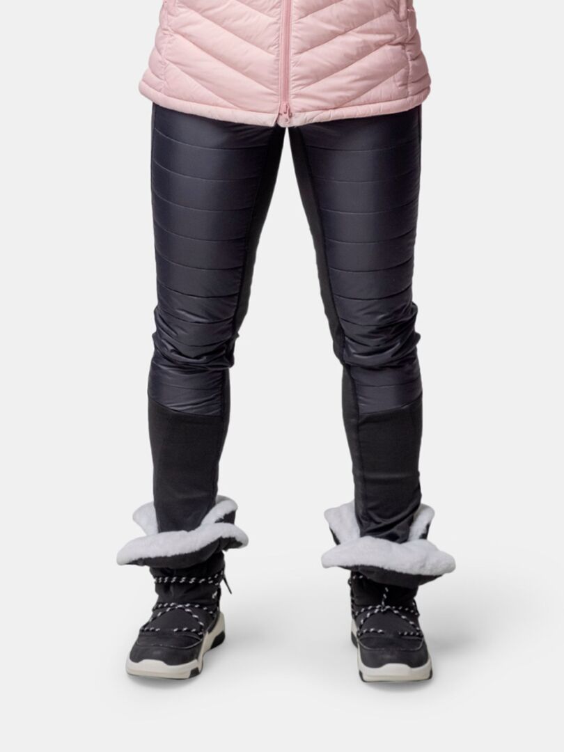 Person trägt eine schwarze wattierte Hose, eine rosafarbene Jacke und Halti Jeti DX Winterstiefel Damen mit weißem Pelzfutter, knieabwärts.