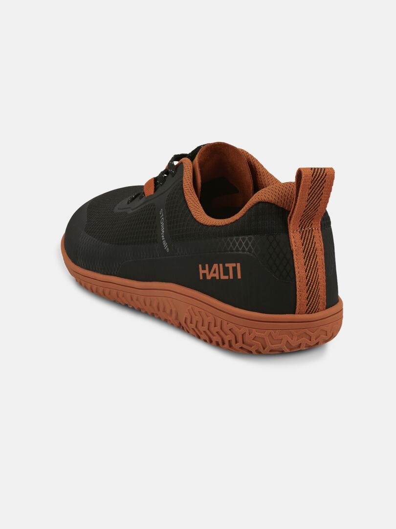Schwarzer und brauner Halti Tuntuma Barfußschuh für alle, schräg dargestellt vor einem schlichten Hintergrund.