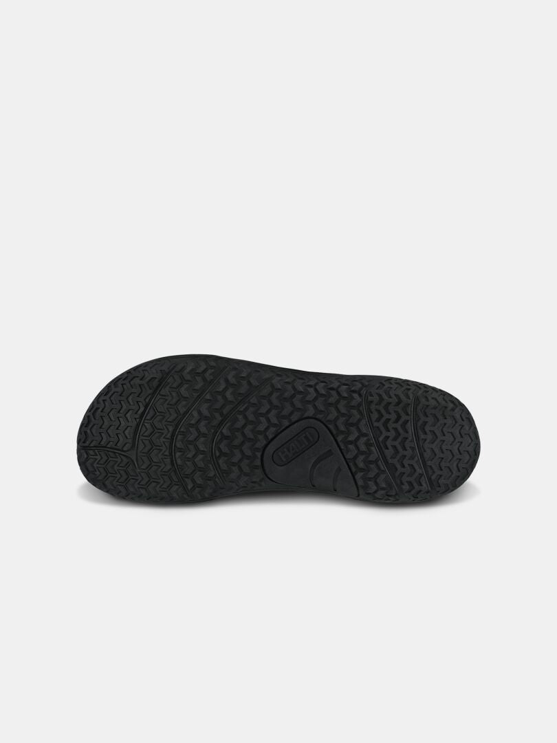 Halti Tuntuma Mid DX Barfußschuh für Herren: schwarze Gummisohle mit strukturiertem Profil, abgebildet auf hellem Hintergrund.