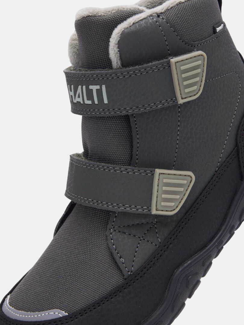 Nahaufnahme der Halti Jalava DX Barfußstiefel für Kinder in Grau mit Klettverschlüssen, profilierter Sohle und Halti-Logo.