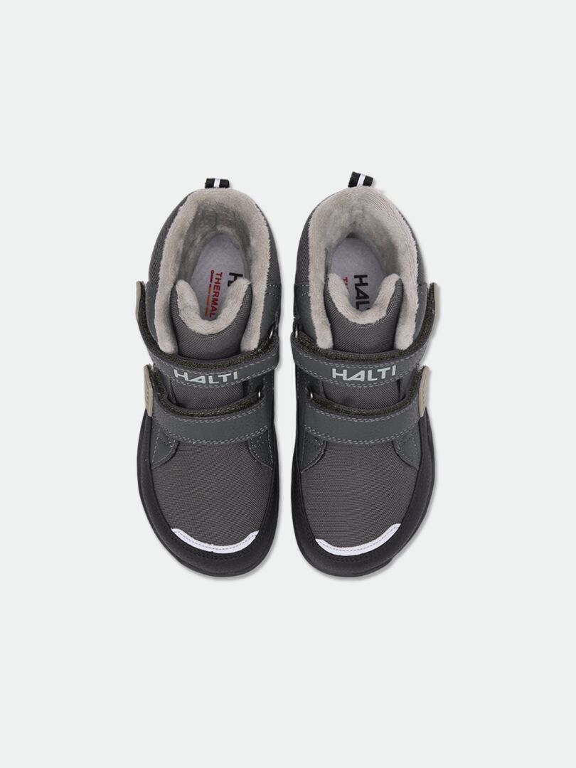 Ein Paar Halti Jalava DX Barfußstiefel für Kinder in Dunkelgrau mit Klettverschluss, von oben auf weißem Hintergrund fotografiert.