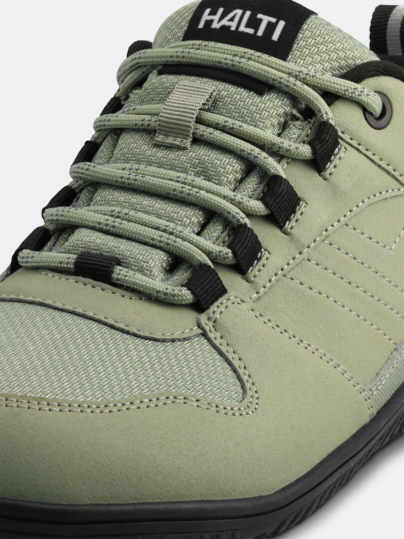 Nahaufnahme des Halti Tuntuma DX Barfußschuh Damen-Sneakers in Hellgrün mit schwarzen Schnürsenkeln und einer schwarzen Gummisohle.