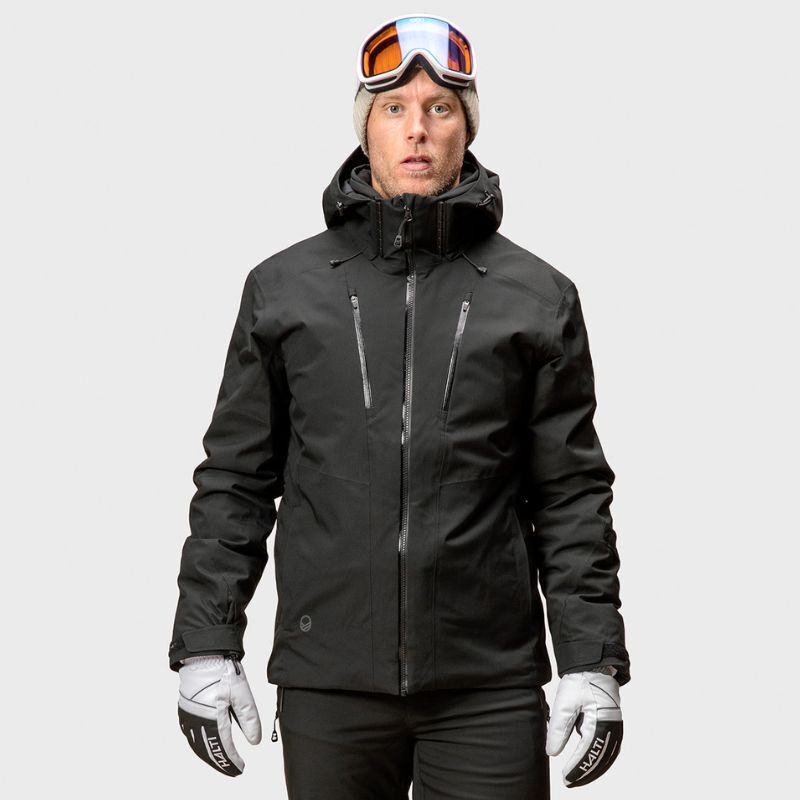 Eine Person trägt die Halti Vertica DX Skijacke Herren, eine graue Mütze und eine Skibrille vor einem einfarbigen Hintergrund.