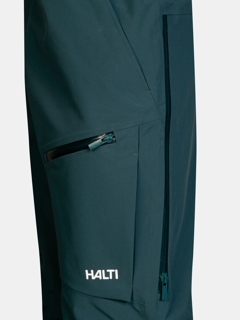 Nahaufnahme der türkisfarbenen Rizle 3L DX Skihose (Unisex) mit Reißverschlusstasche und seitlicher Belüftung.