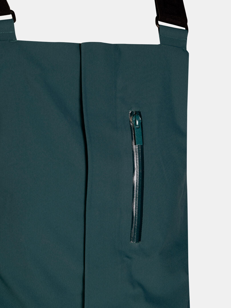 Dunkelblaugrüne Halti Rizle 3L DX Skihose – wasserdichte Unisex-Latzhose mit vertikaler Brusttasche mit Reißverschluss und schwarzen Hosenträgern.