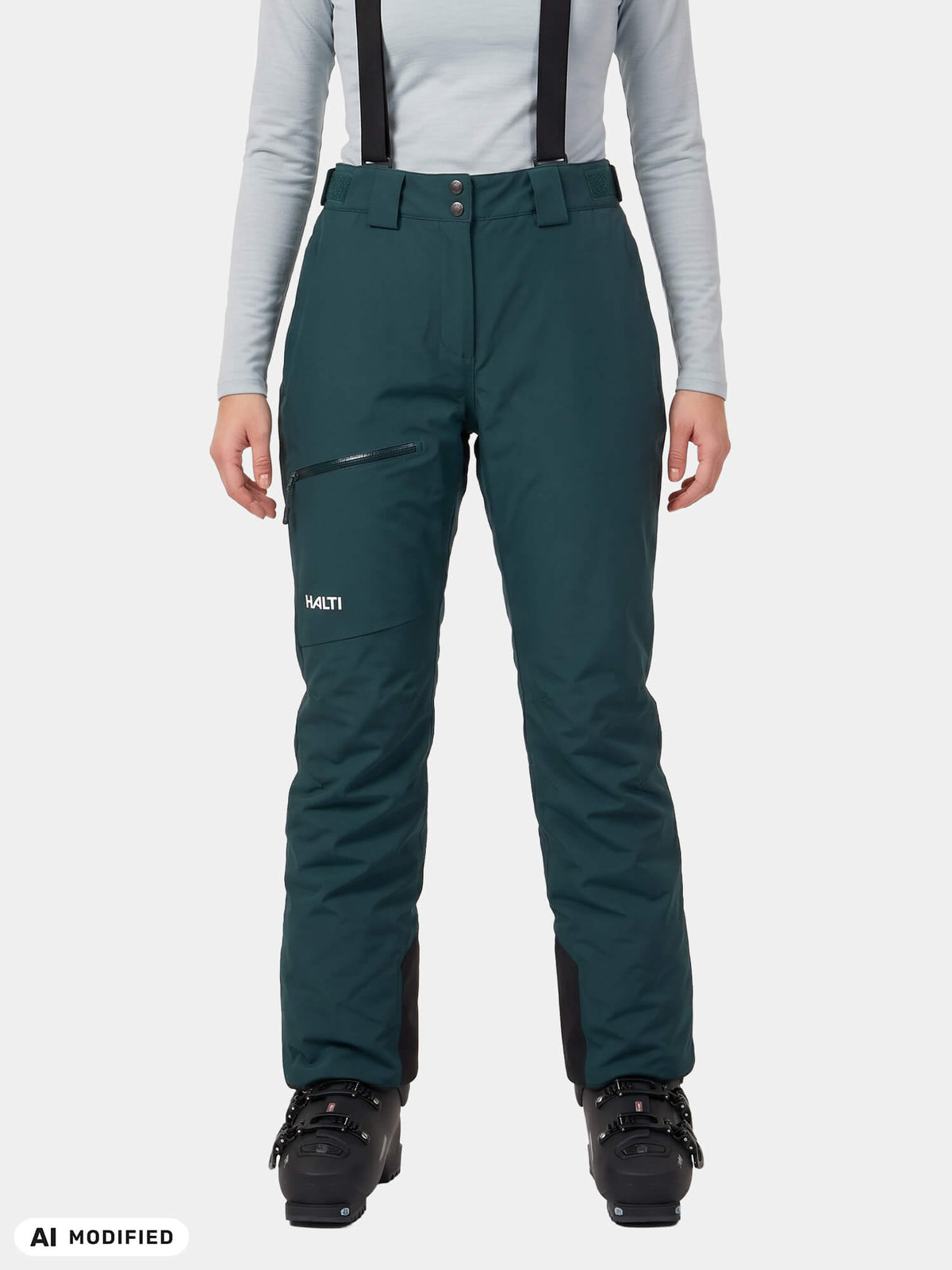 Dunkelgrüne Carvey II DX Skihose für Damen mit schwarzen Hosenträgern, getragen mit Skischuhen für den Wintersport.