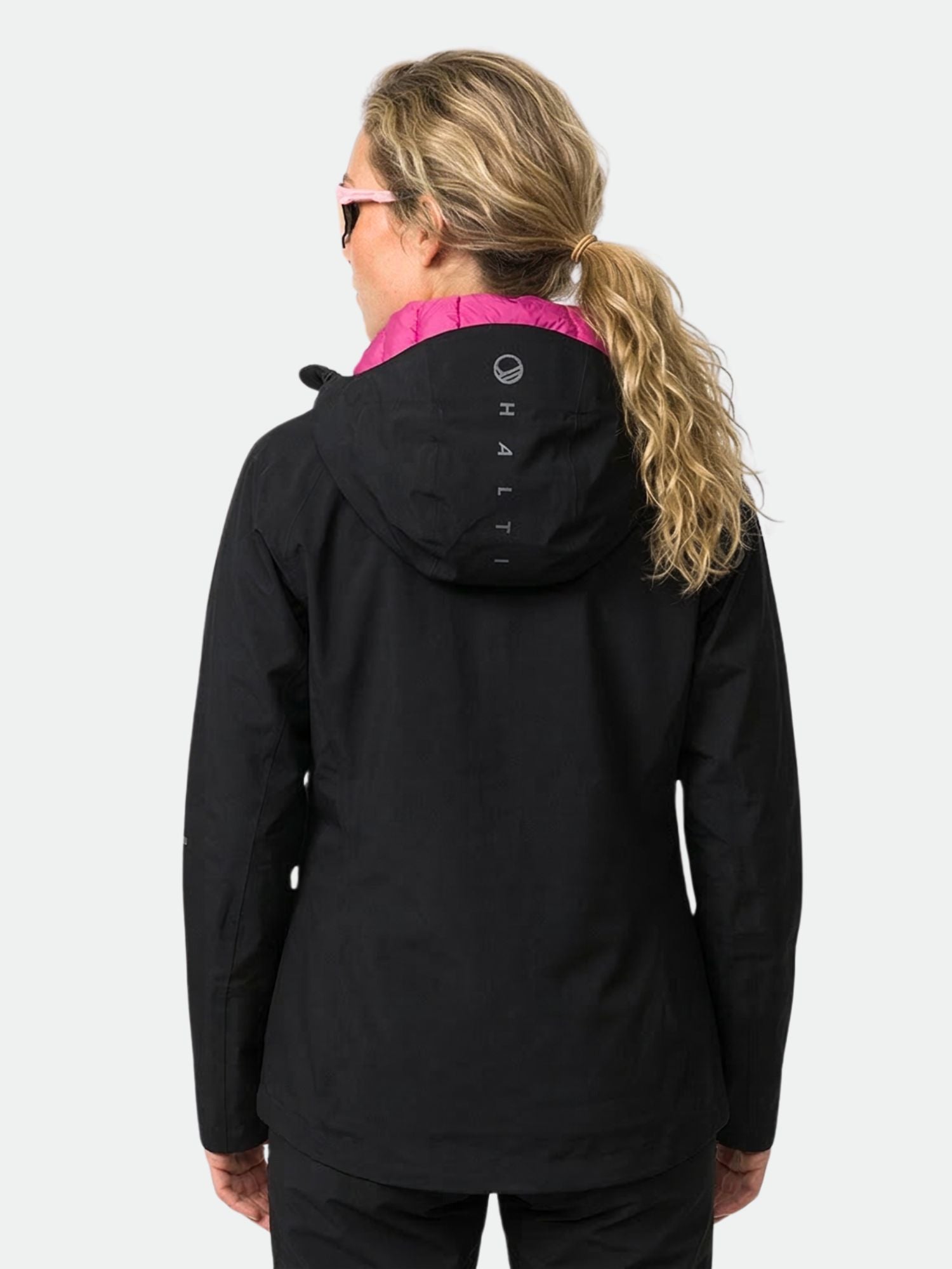 Eine Frau mit langen blonden Haaren trägt die Halti Kaarna Damen DX 3L Regenjacke, ideal für Aktivitäten im Freien.