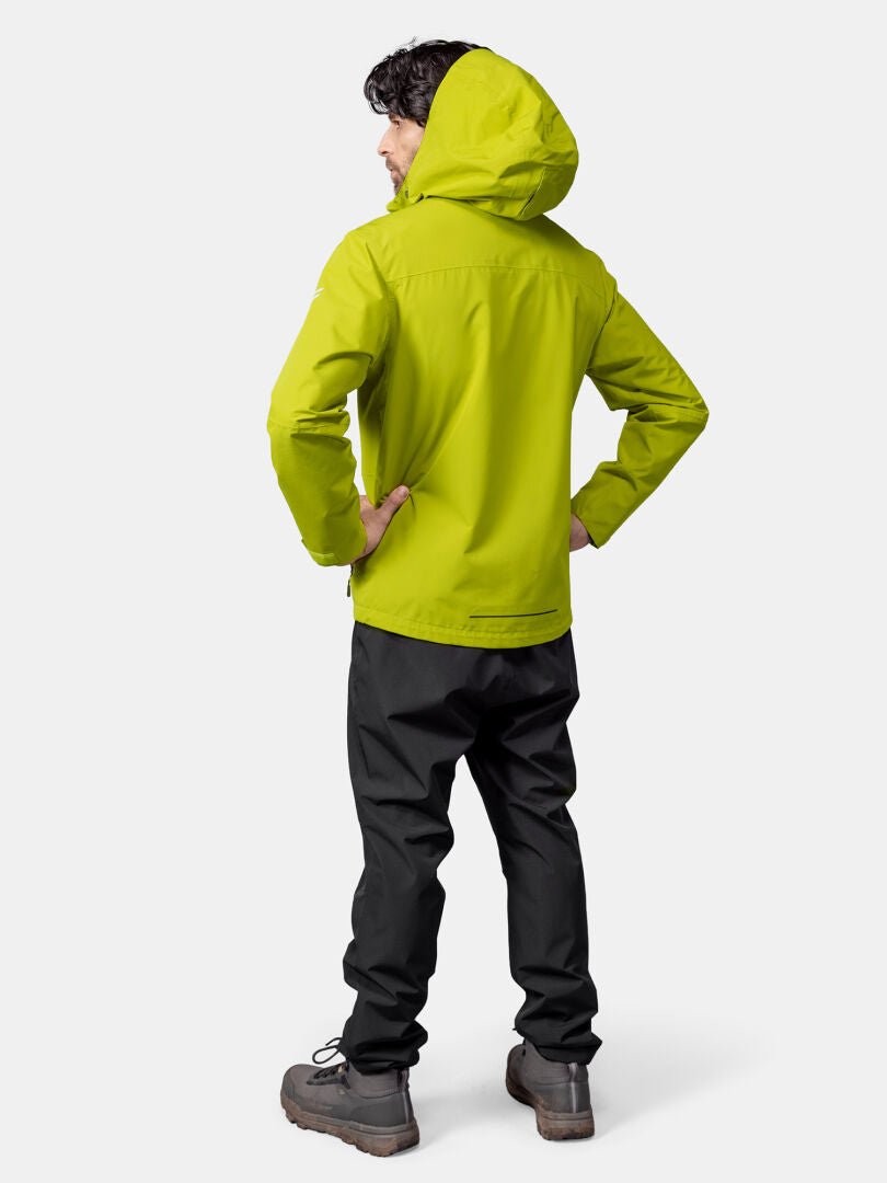 Ein Mann trägt die Halti Forter DX Regenjacke, schwarze Hose und braune Stiefel vor neutralem Hintergrund.