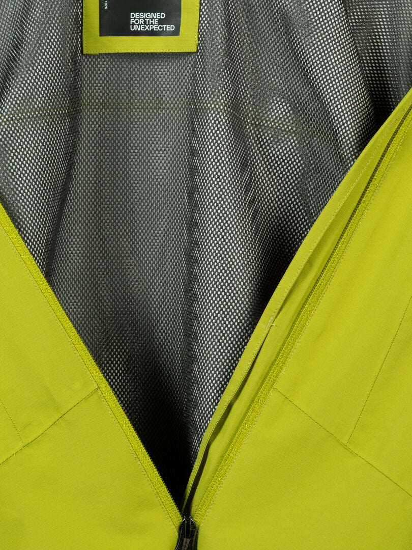 Nahaufnahme der gelben Halti Forter DX Regenjacke Herren, die nach dem Öffnen des Reißverschlusses ihr Netzfutter zeigt - ideal als Wetterschutzjacke.