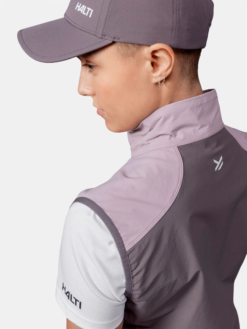 Person mit einer grauen Halti-Mütze, Pallas Evo X-stretch Weste Damen und weißem Hemd, von hinten gesehen.