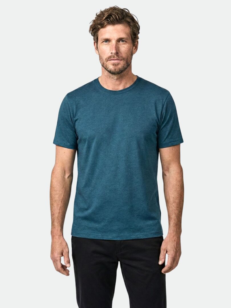 Mann mit Blick nach vorne in einem tealfarbenen Halti Tuntu II Merinoshirt Herren und schwarzer Hose, perfekt als Outdoor-Shirt.