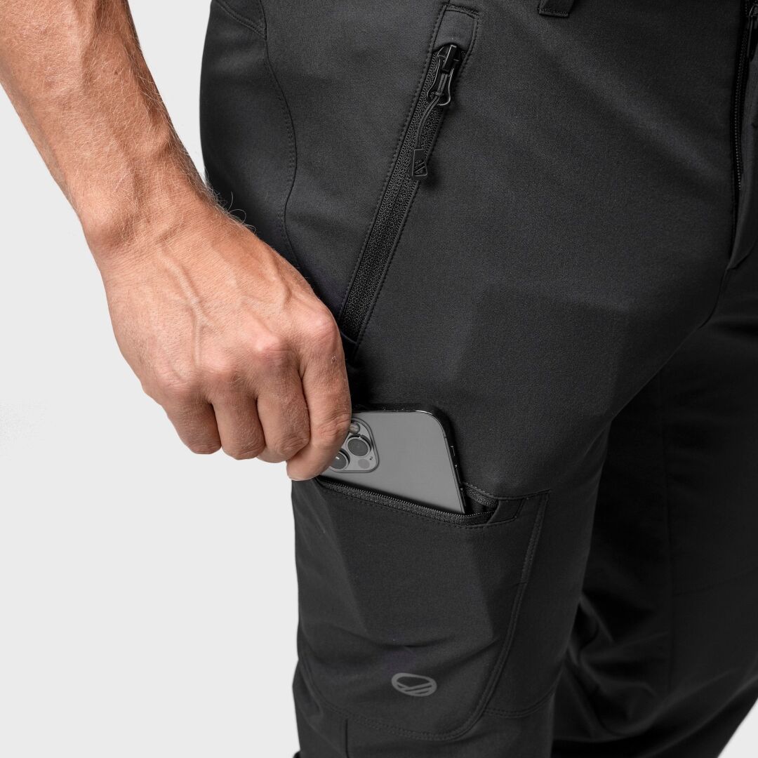 Jemand steckt ein Smartphone in die Seitentasche der Halti Pallas Evo Brushed X-Stretch Hosen Herren mit Reißverschluss darüber.