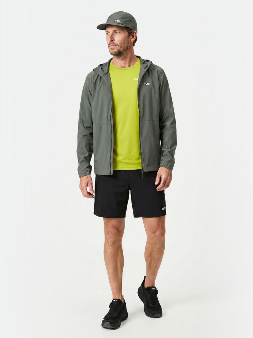 Ein Mann in einer Halti Pisarat 2,5L DX Regenjacke Herren steht vor einem weißen Hintergrund.