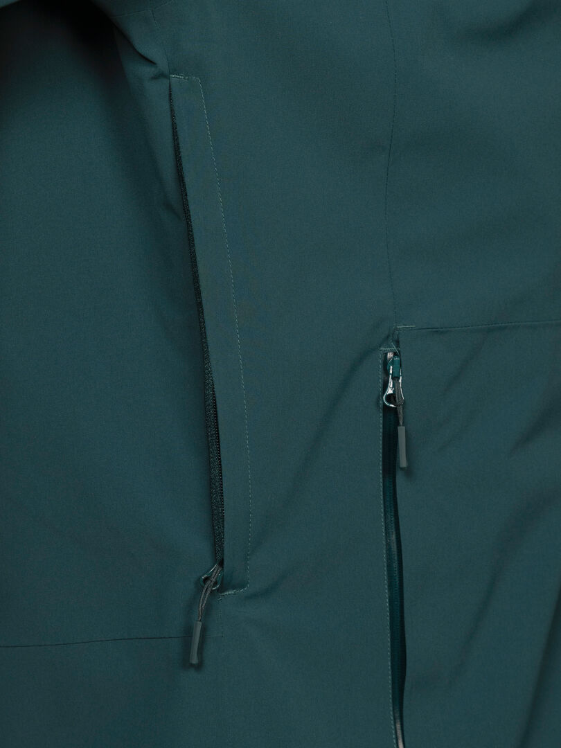 Nahaufnahme der Halti Staala DX Regenjacke für Herren mit zwei Reißverschlusstaschen und sichtbaren Nähten für den Outdoor-Einsatz.