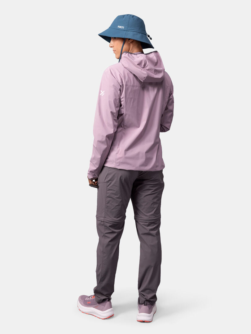 Mit der Halti Pallas Cool X-stretch Jacke Damen und der blauen Mütze ist sie bereit für den Outdoor-Spaß auf hellem Grund.