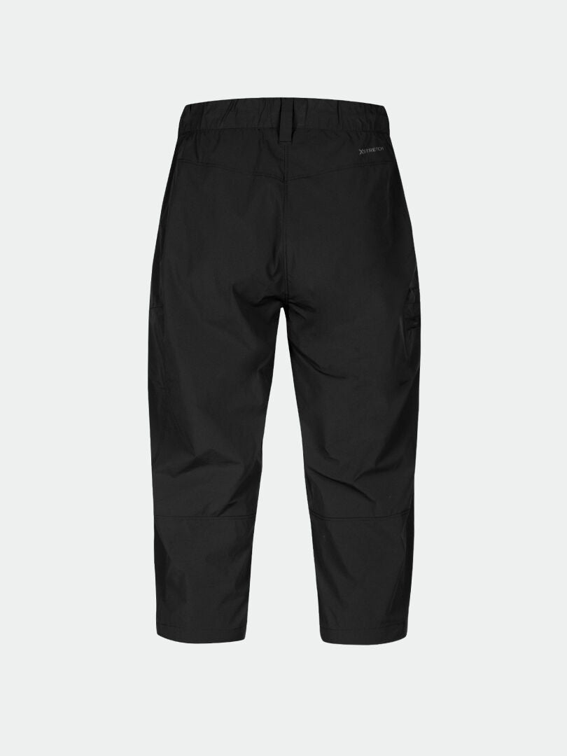 Die Halti Pallas Cool X-Stretch Caprihose Damen in Schwarz, von hinten vor hellem Hintergrund dargestellt.