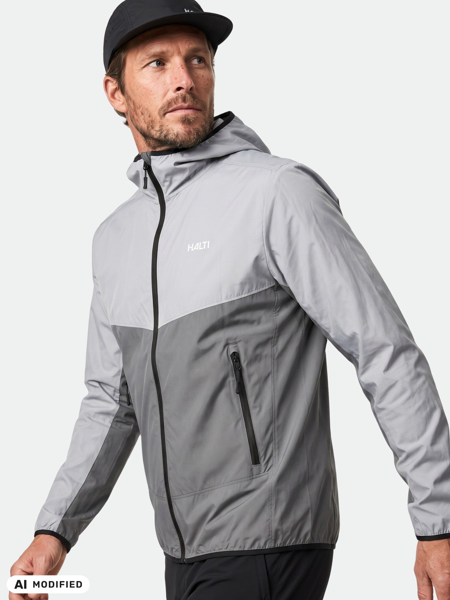 Ein Mann in einer „Halti Pallas Cool X-Stretch“-Herrenjacke und einer schwarzen Mütze blickt zur Seite – geschützt durch Sonnenschutz mit UPF 50+.