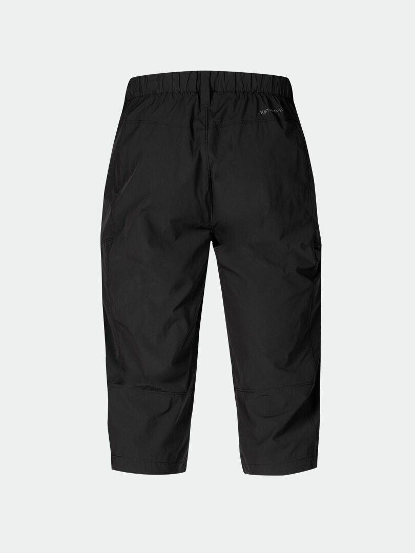 Die Halti Pallas Cool X-Stretch Caprihose Herren in Schwarz, mit elastischem Bund, von hinten auf unifarbenem hellem Untergrund abgebildet.