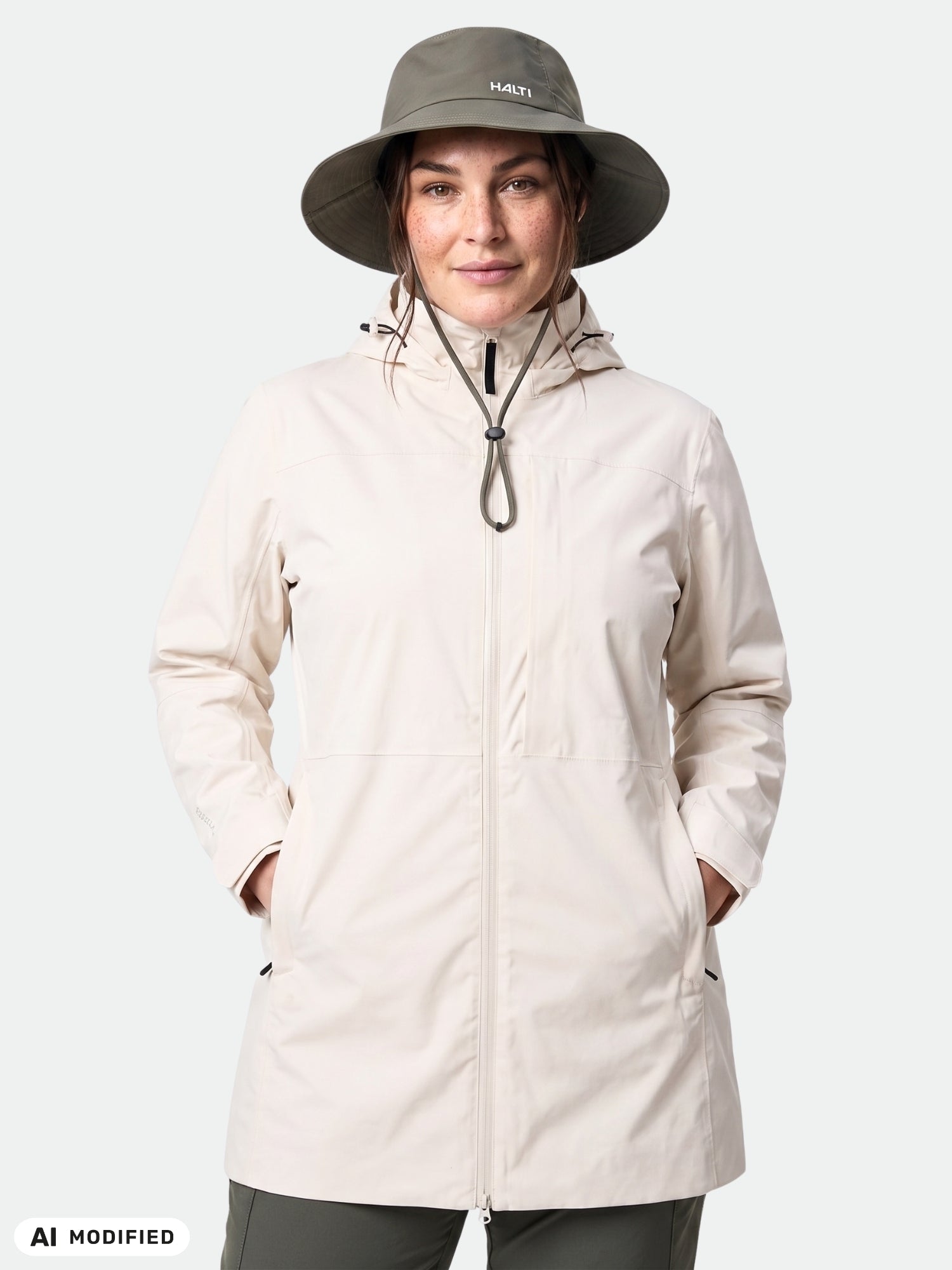 Eine Person in einer „Halti Kallas DX Parka Jacke Plus Damen“ blickt nach vorne, die Hände in den Taschen, und trägt einen Hut mit breiter Krempe.