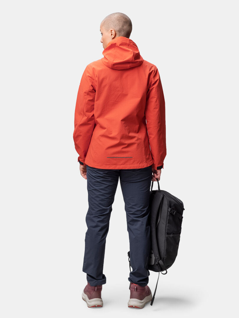 Person in einer Halti Finholma X-stretch Damenjacke, dunkle Hose, die einen schwarzen Rucksack in der linken Hand hält.