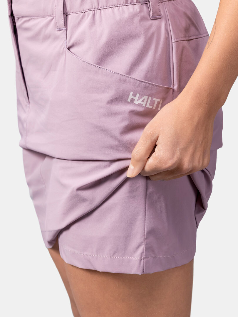 Eine Person dehnt den Saum des hellvioletten Halti Pallas Cool Rock Damen und zeigt damit die Flexibilität des Stoffes.