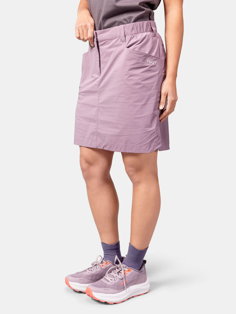 Eine Person in einem Halti Pallas Cool Rock Damen und lila Socken steht vor einem schlichten weißen Hintergrund.