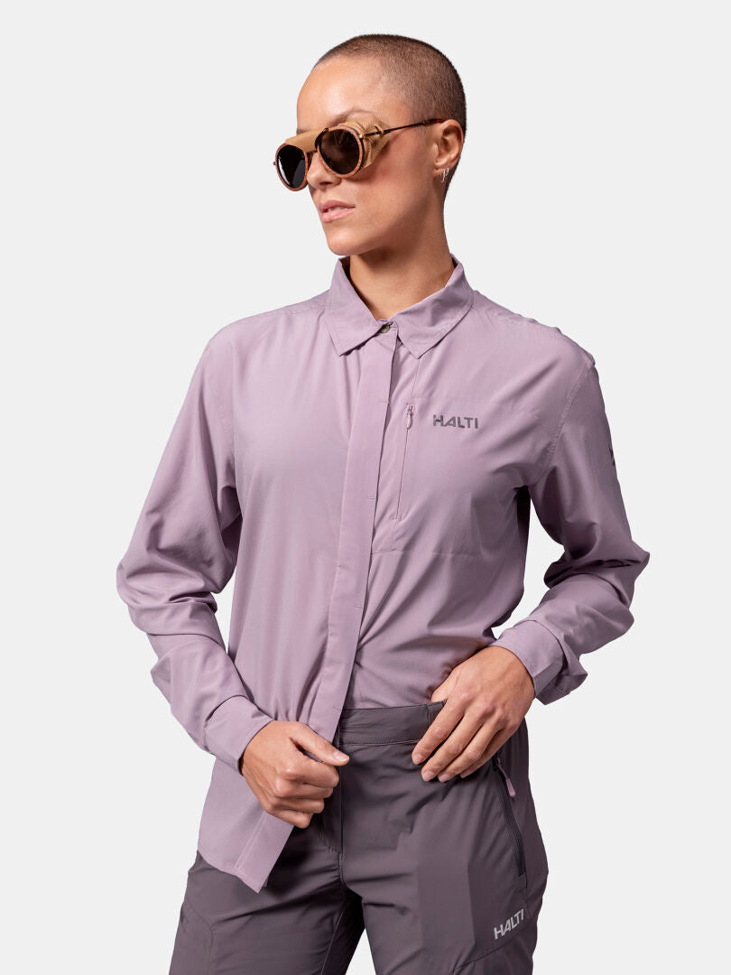 Eine Person mit rasiertem Kopf trägt eine Sonnenbrille und ein Halti Samoy Langarm Funktionshemd Damen mit grauer Hose.