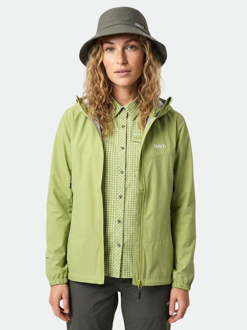 Eine Frau trägt die Halti Pallas Evo X-stretch-Jacke und steht vor neutralem Hintergrund.