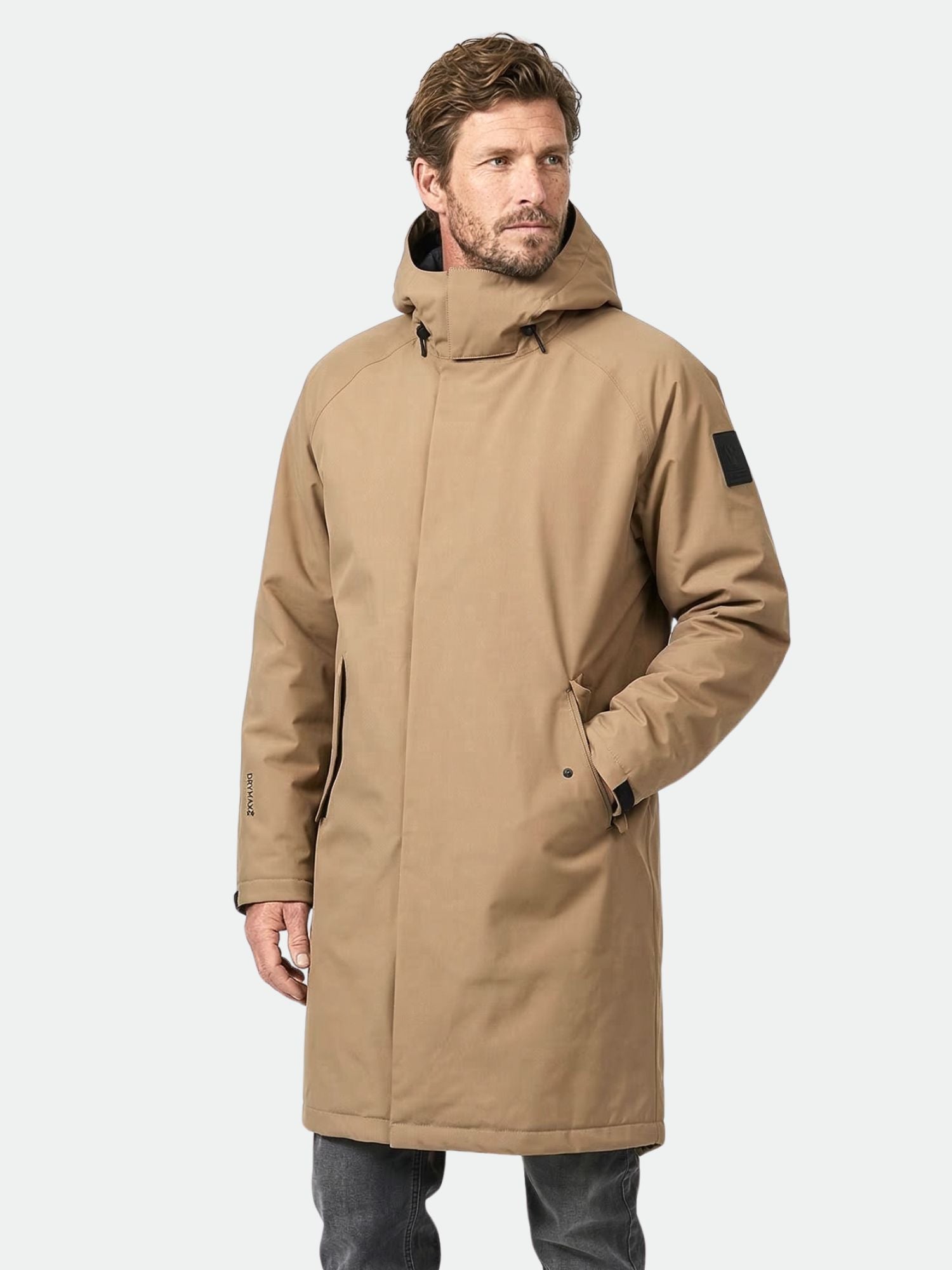 Ein Mann trägt die Halti Flemari DX Parka Jacke Herren, hergestellt aus DrymaxX All Weather-Material, vor einem unifarbenen Hintergrund.