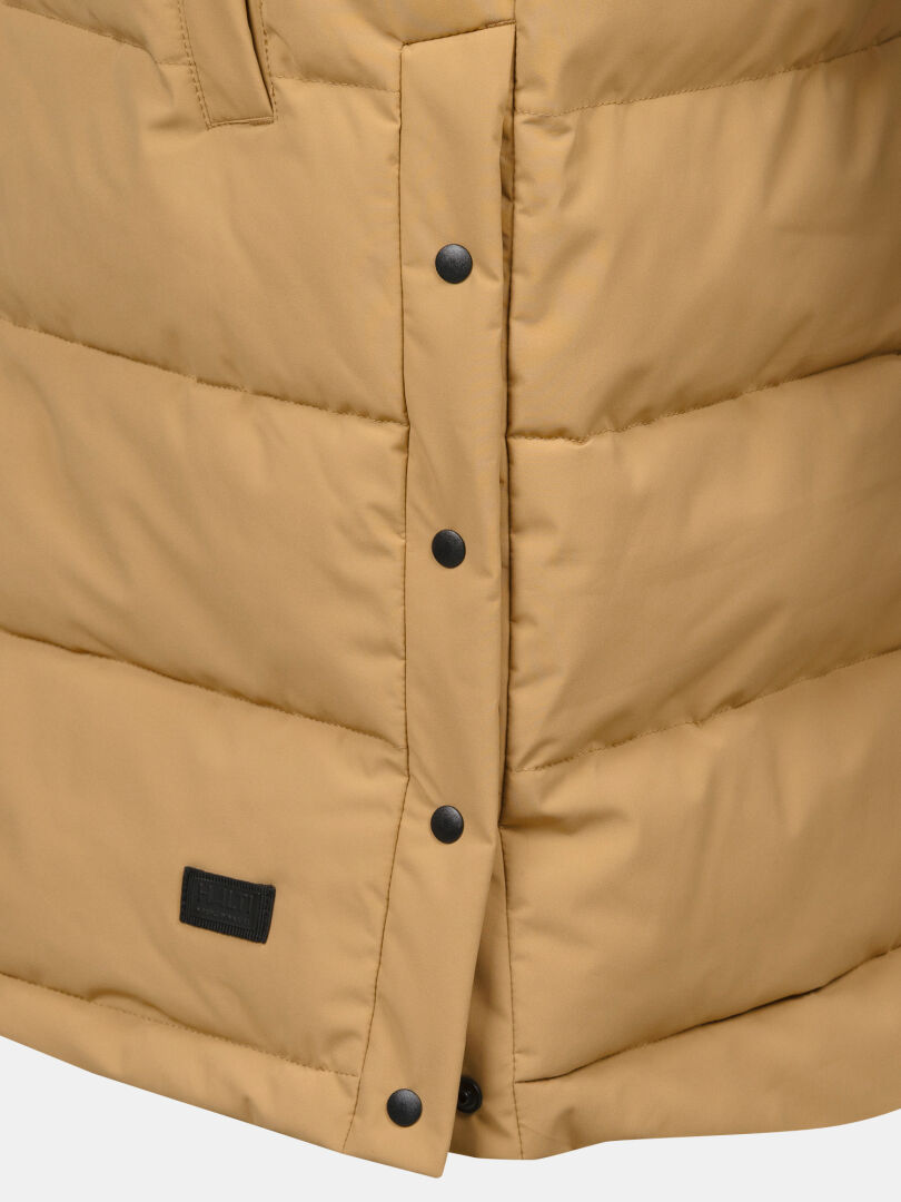 Nahaufnahme einer hellbraunen Halti Penger Puffer Weste Damen mit Druckknöpfen und einem kleinen schwarzen Aufnäher im unteren Bereich.