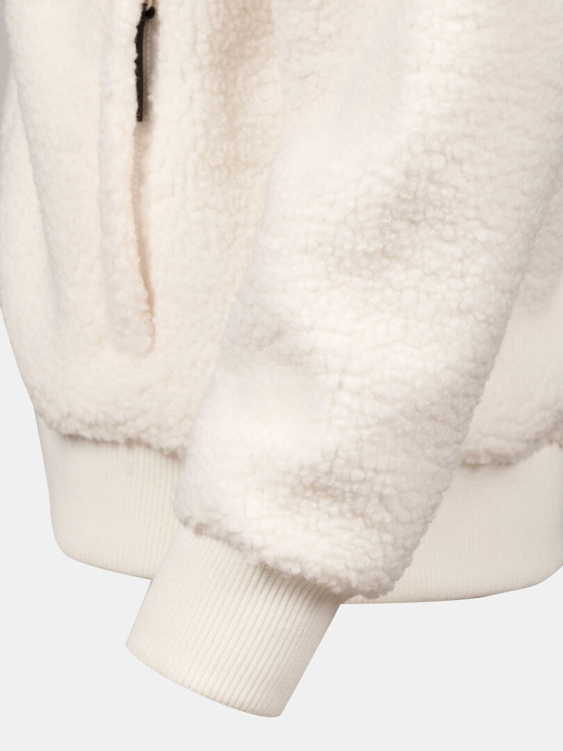 Nahaufnahme des Ärmels der Halti Lykky Fleece Jacke Damen aus recyceltem Polyester, mit Rippenbündchen und Reißverschlusstasche.