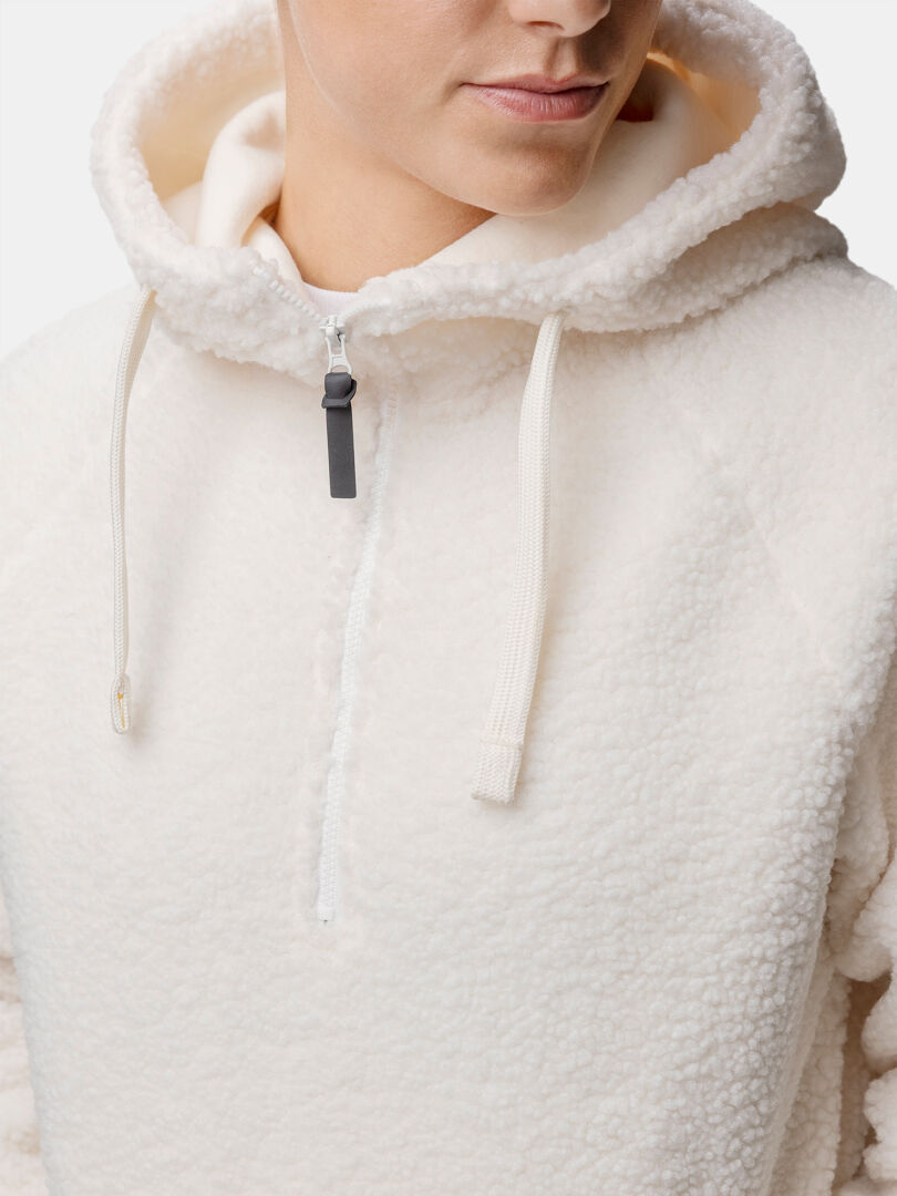 Frau trägt einen cremefarbenen Halti Lykky Fleecepullover Damen aus recyceltem Polyester, von den Schultern aufwärts gezeigt.