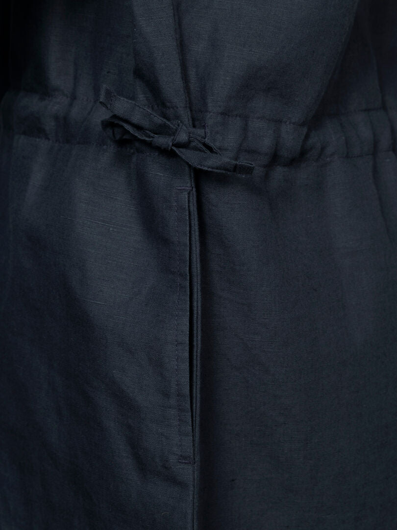 Nahaufnahme eines dunklen Halti Notsgi Kleid Damen mit einem schmalen Bindegürtel, der in der Taille mit einer Schleife befestigt ist.