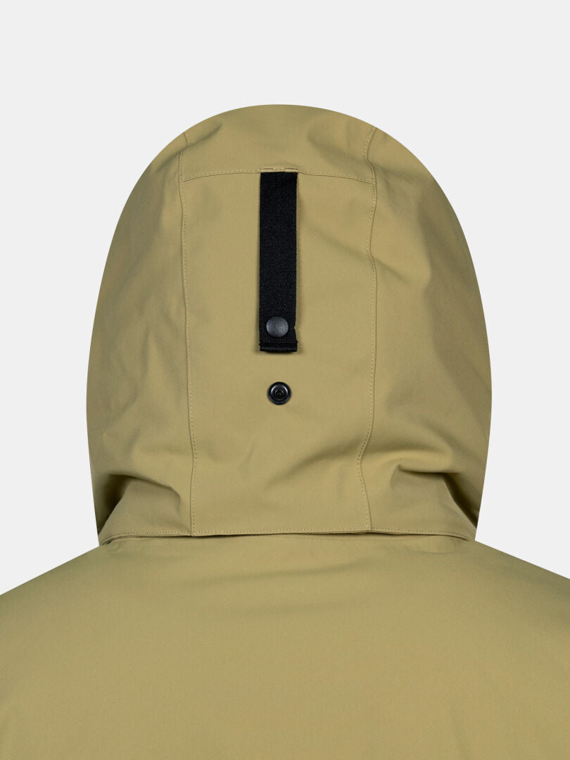 Nahaufnahme der Rückseite eines hellbraunen Halti Kallio DX Parka für Herren mit schwarzem Riemen und Druckknopfdetails.
