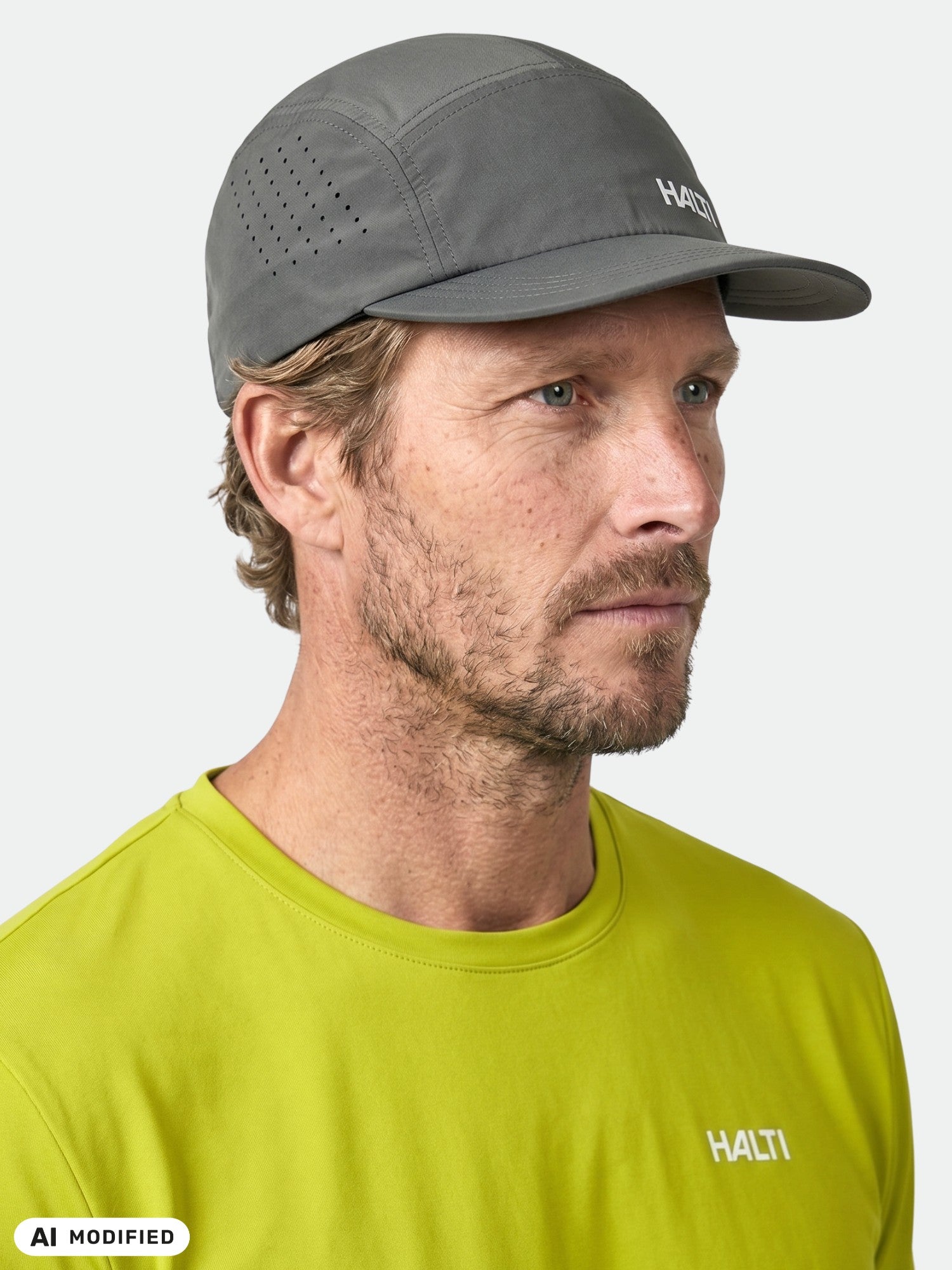 Ein Mann mit einer grauen Halti Luovi-Mütze und einem limettengrünen Halti-Shirt blickt nach rechts vor einem schlichten, hellen Hintergrund.
