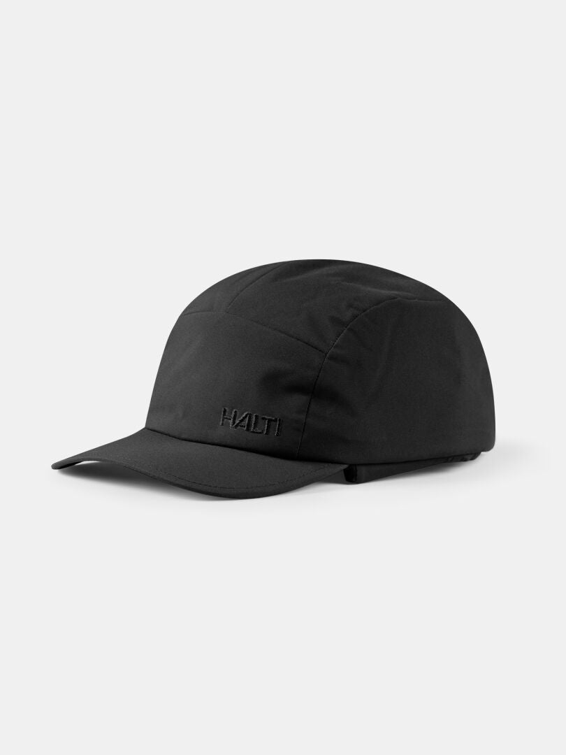 Halti Huove Puffy Hut, schwarze Baseballkappe mit gebogener Krempe, ideal für Outdoor-Aktivitäten. Weißer Hintergrund.