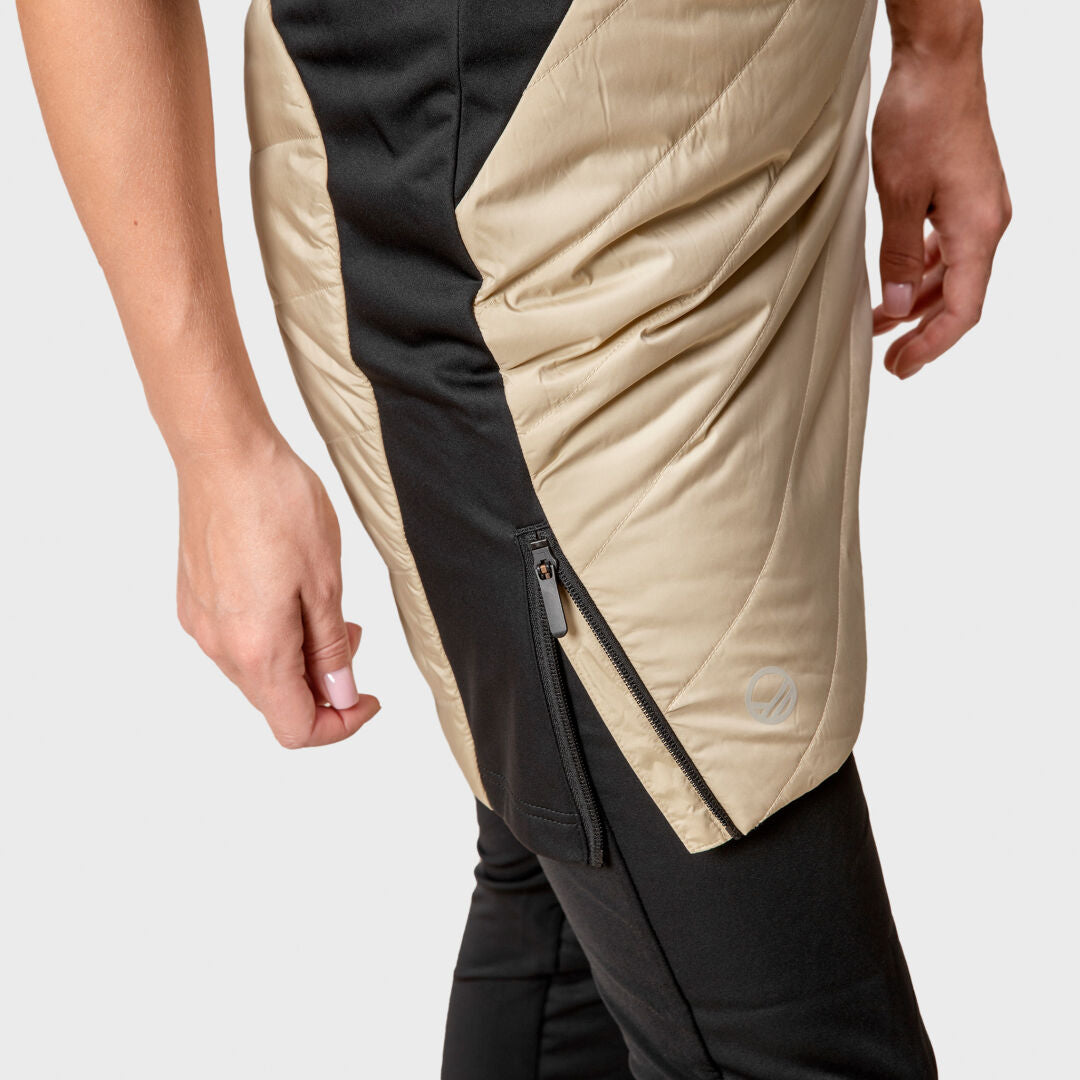 Eine Frau trägt den Halti Hanki Hybrid Rock Damen mit sichtbarem Reißverschluss und steht vor einem schlichten Hintergrund.