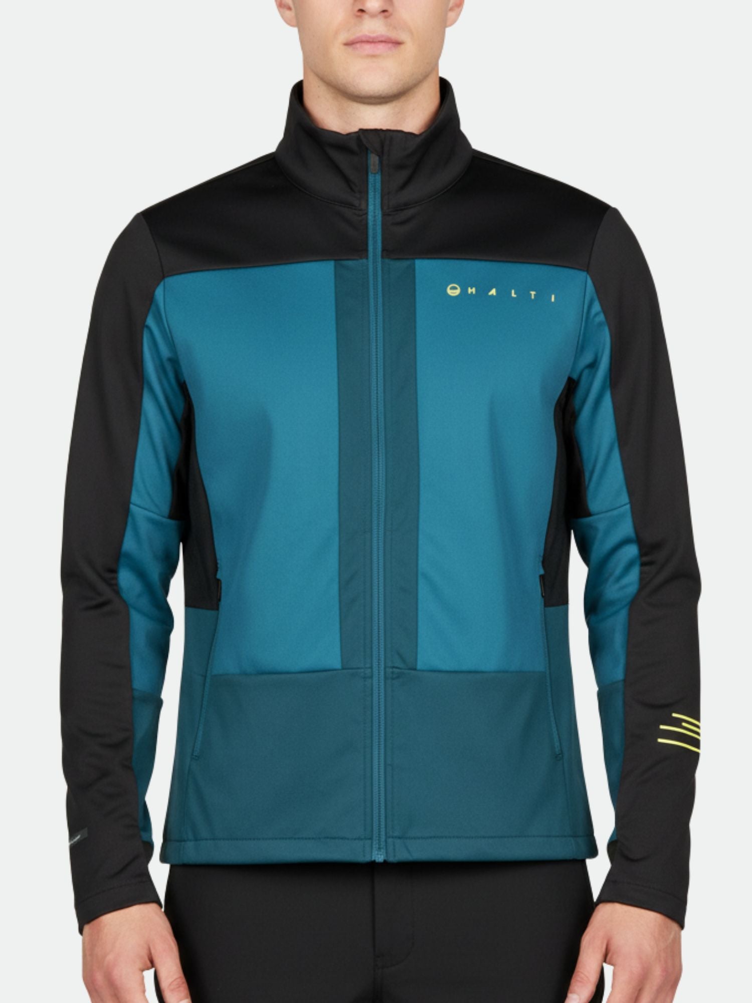 Ein Mann trägt eine teal-schwarze Halti Vinha Langlaufjacke Herren; sie ist winddicht und atmungsaktiv.