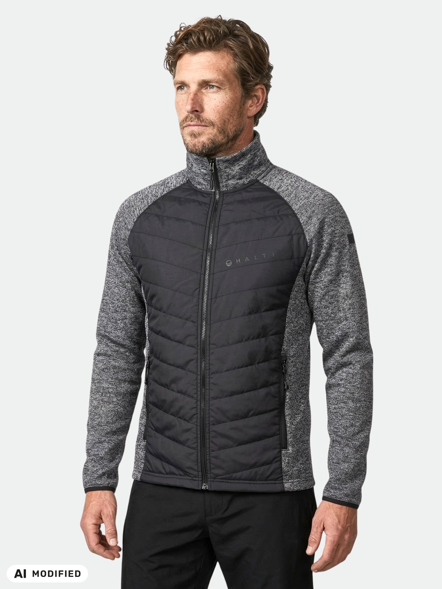 Ein Mann trägt die Halti Streams Hybrid Layer Jacke für Herren mit langen Ärmeln vor einem einfarbigen, hellen Hintergrund.