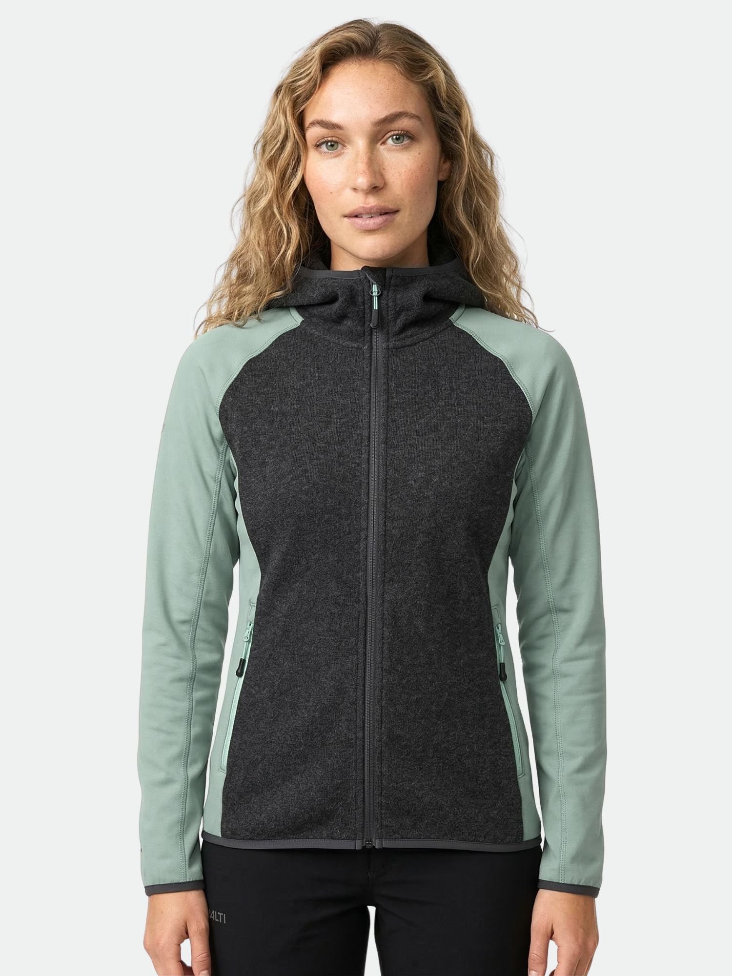 Eine Frau schaut nach vorne in einem Halti Circuit II Hoodie Damen, der mit Active Dry Material für Outdoor-Aktivitäten ausgestattet ist.