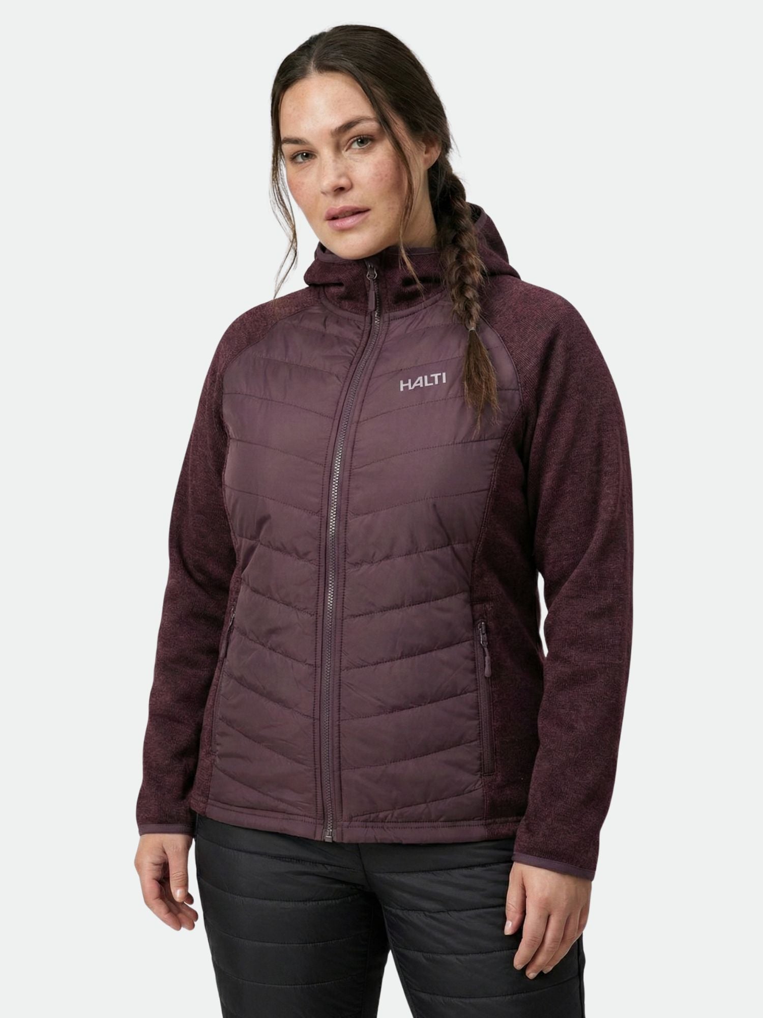 Eine Frau trägt eine kastanienbraune Halti Streams Hybrid Layer Jacke Damen Plus mit einem Frontreißverschluss - ideal für Aktivitäten im Freien.