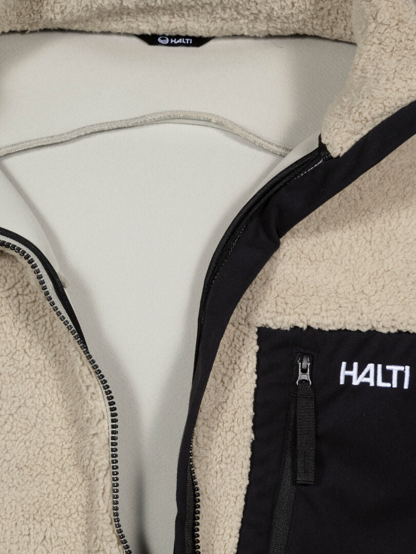 Nahaufnahme der Halti Lumista Polar Fleece Jacke Herren mit einer schwarzen Brusttasche mit Reißverschluss, die teilweise geöffnet ist, um das Futter zu zeigen.