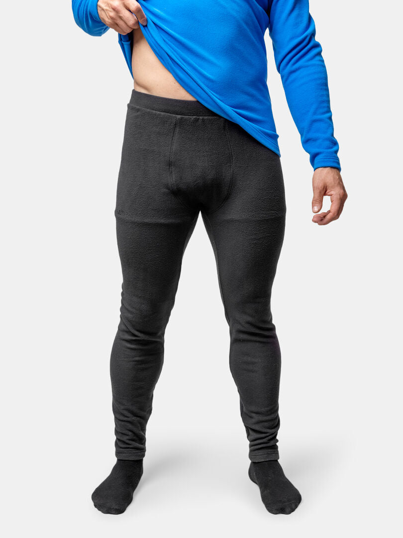 Mann mit Halti Trone Fleece-Hosen, der ein blaues langärmeliges Hemd anhebt, um den Bund zu zeigen, auf weißem Hintergrund.