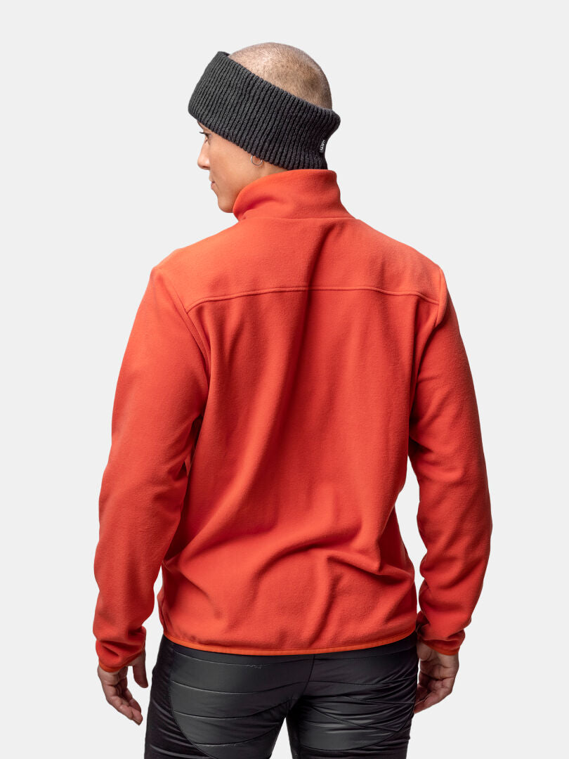 Eine Person trägt eine Halti Rockmoon Fleece Jacke Damen, eine schwarze Hose und ein dunkles Stirnband, dargestellt von hinten auf einfarbigem Hintergrund.