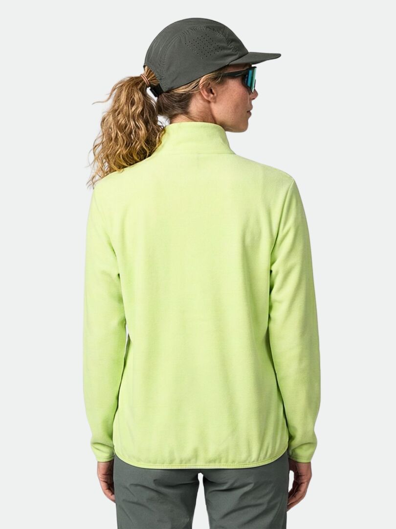 Person, die eine hellgrüne Halti Rockmoon Fleecejacke Damen, eine graue Mütze und eine Sonnenbrille trägt, von hinten gesehen.