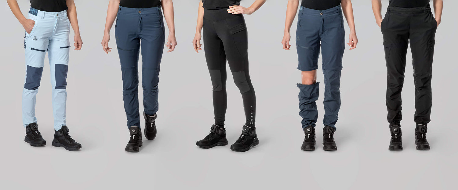 Fünf Frauen stehen nebeneinander und tragen verschiedene Arten und Farben von Wanderhosen mit schwarzen Stiefeln auf einem schlichten Hintergrund.