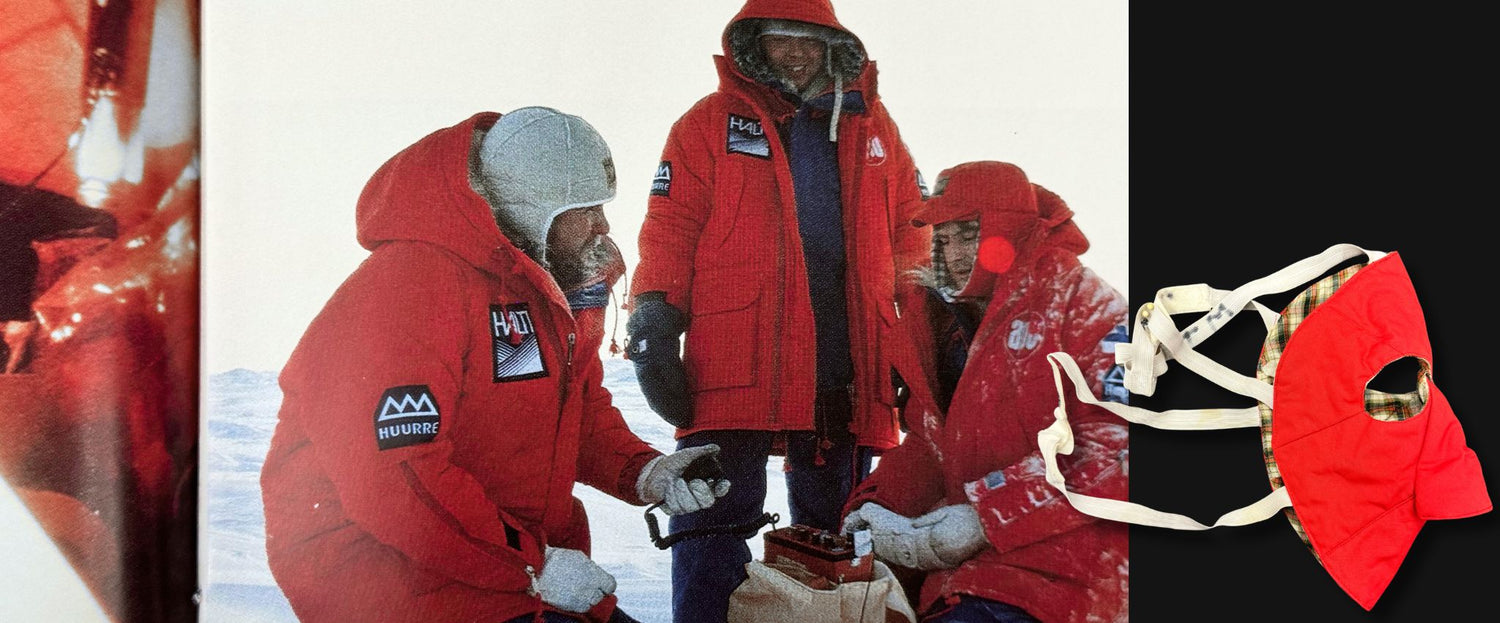 Drei Personen in roten Winterjacken stehen im Schnee; rechts ist eine rote Gesichtsmaske mit weißen Bändern vor schwarzem Hintergrund zu sehen.