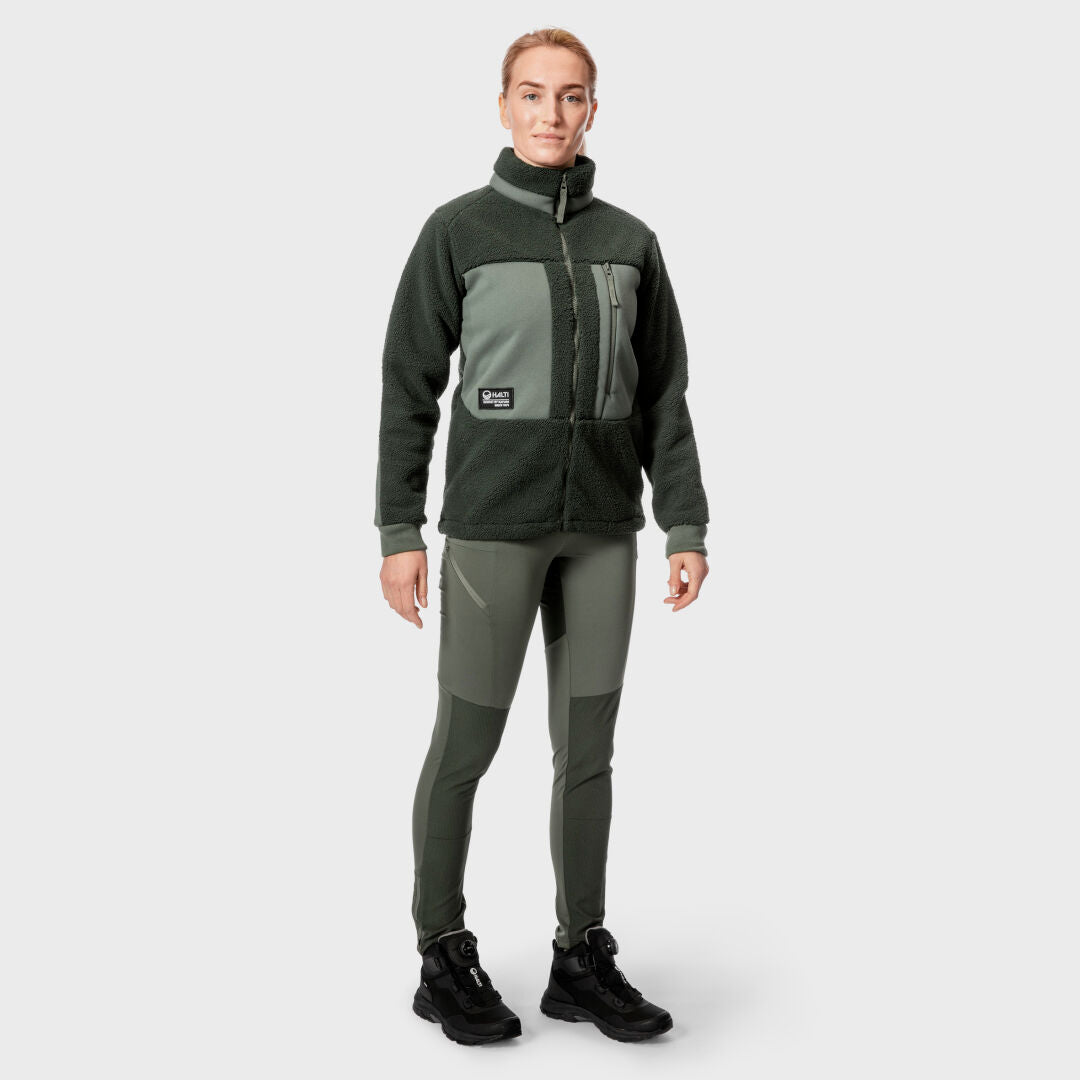 Die Person trägt eine grüne Halti Hiker Damen Polar Fleece Jacke und eine passende Hose und steht vor einem schlichten hellgrauen Hintergrund.