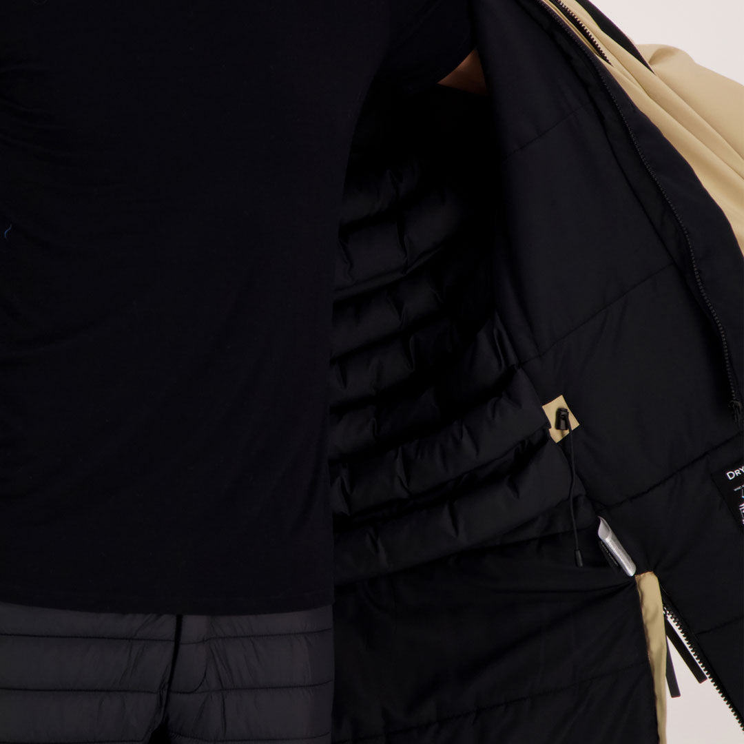 Eine Person in Schwarz öffnet einen Halti Bergga DX Winter Parka Damen und zeigt dessen gesteppte Innenseite - perfekt für eine warme Winterjacke.